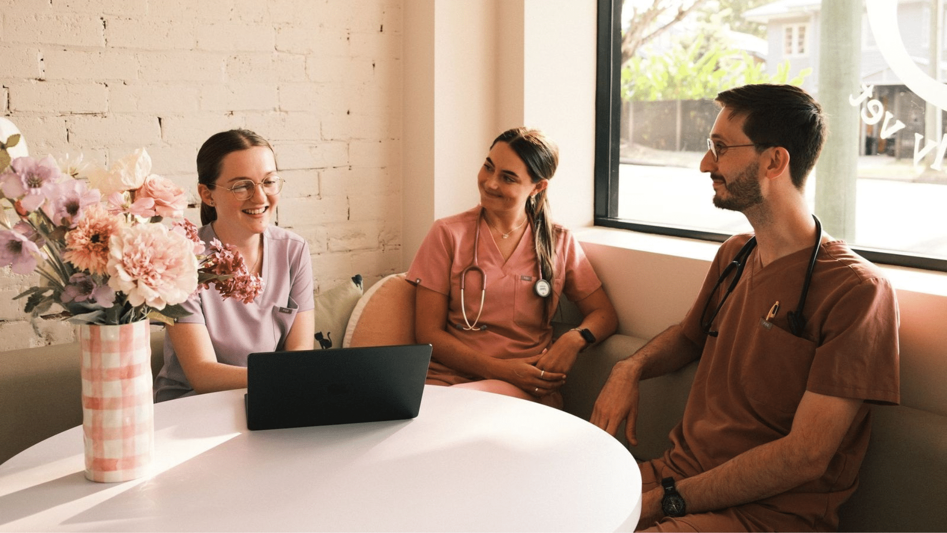 group of cheerful Hey Bud veterinary team members gathered around table in lobby